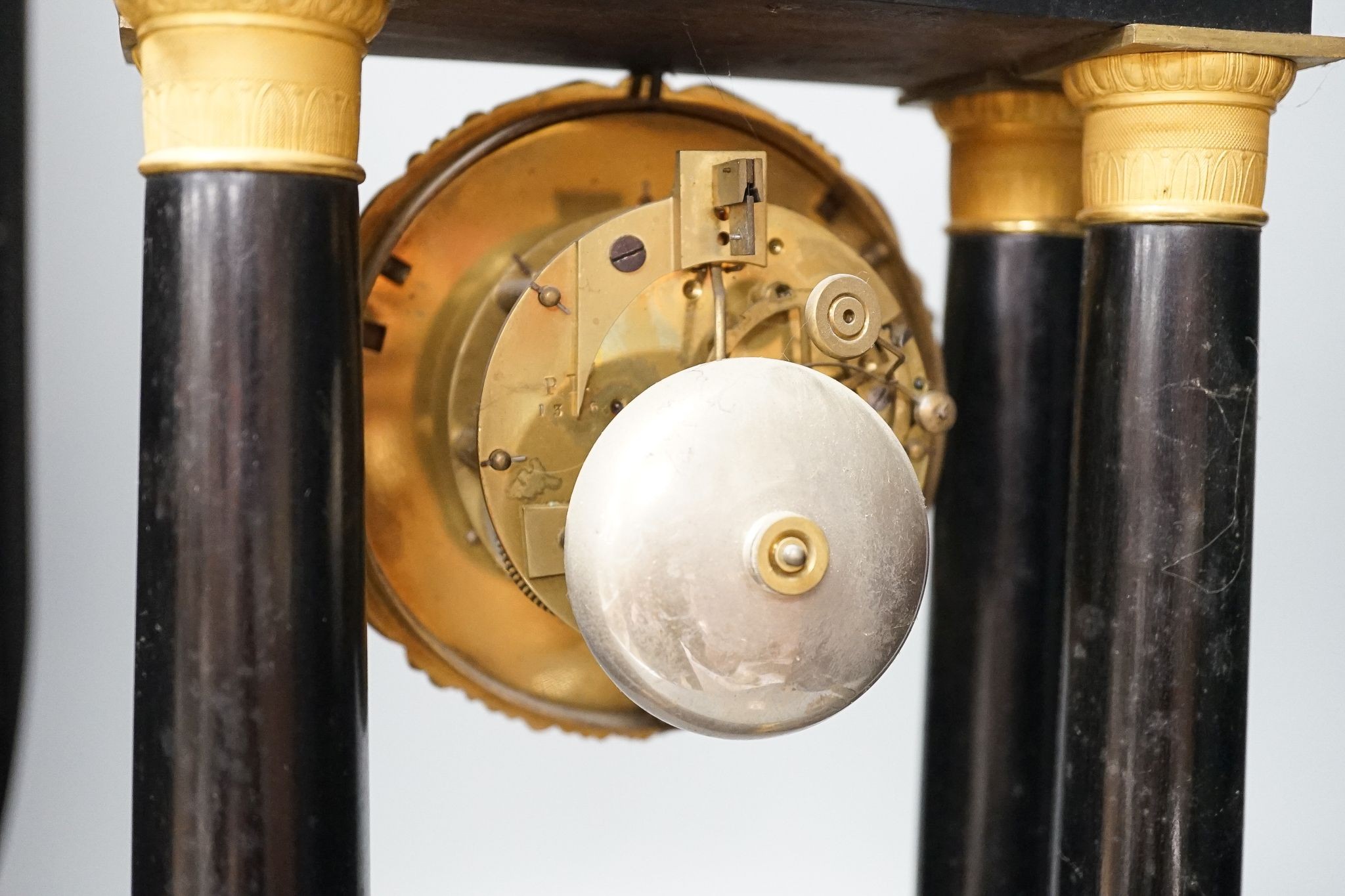 A 19th century ebonised portico mantel clock with brass mounts, 46cms high.